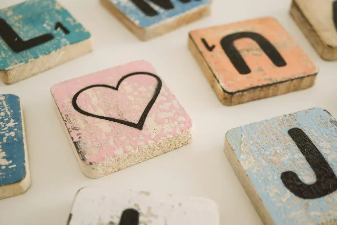 scrabble blocks and heart block on white surface